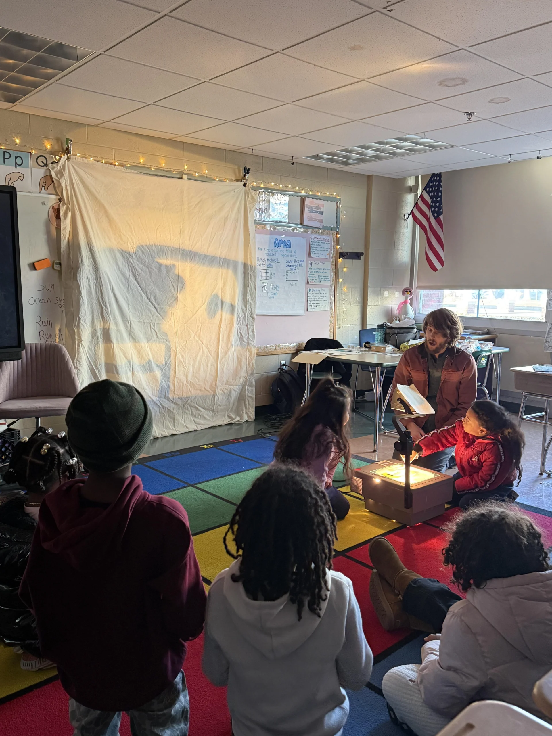 students and teacher using a projector in classroom