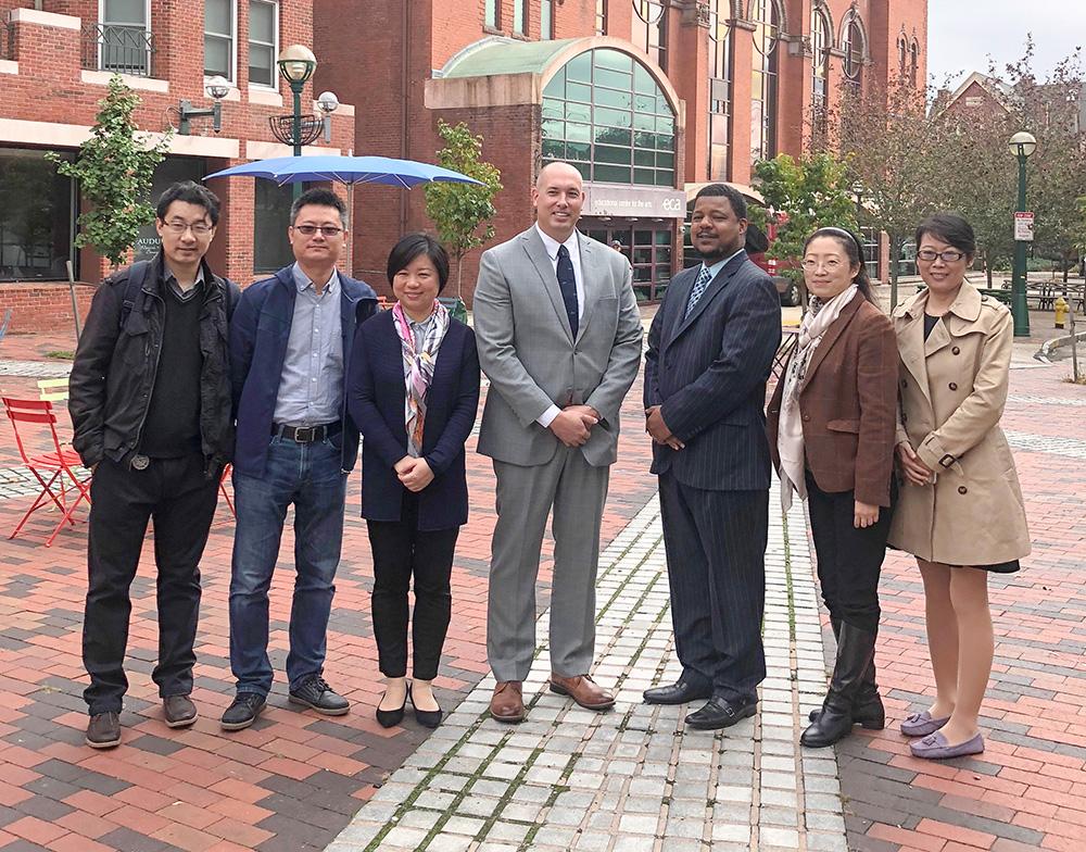 "The Visiting Scholars team poses for a photo in front of ACES ECA School.”