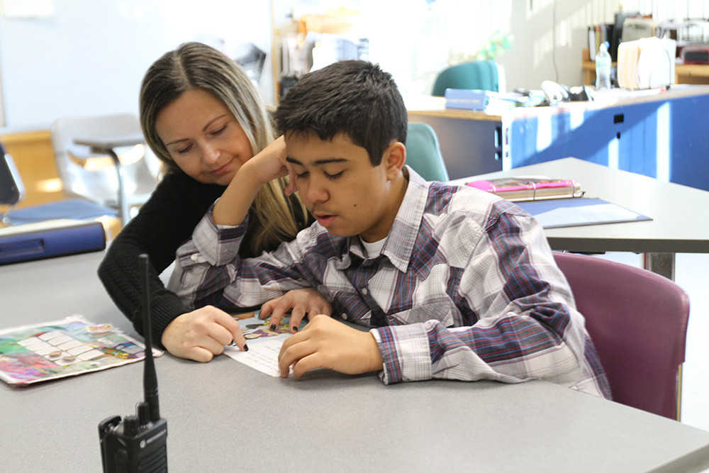 Teacher assisting student.