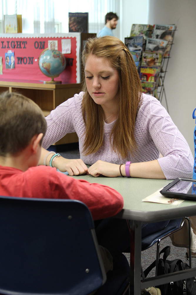 Teacher assisting student.