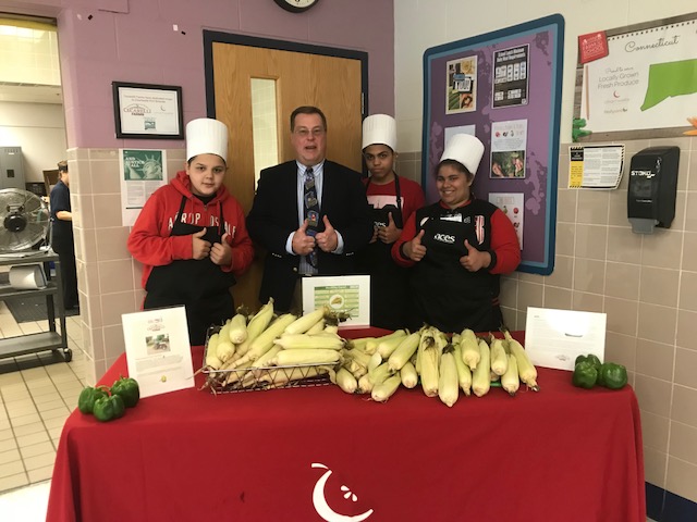 Students shucking corn at ACES Mill Road School