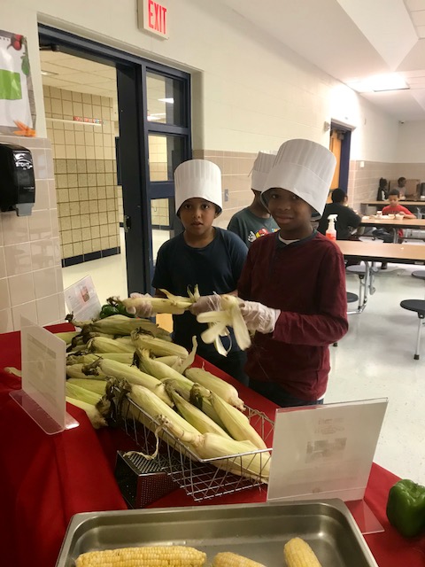 Mill Road students shucking corn