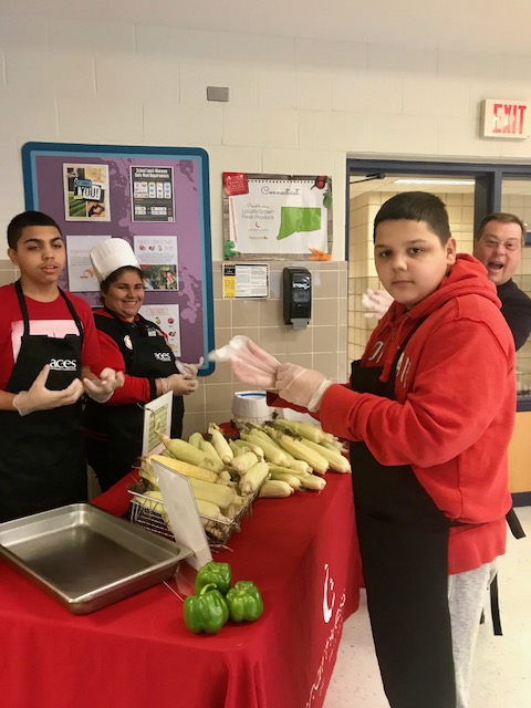 Mill Road student shucking corn