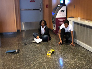 students sitting on floor with robotic cars