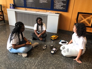 students sitting on floor with robotic cars