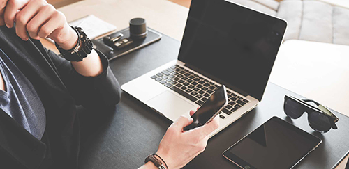 Man on phone in front of a laptop