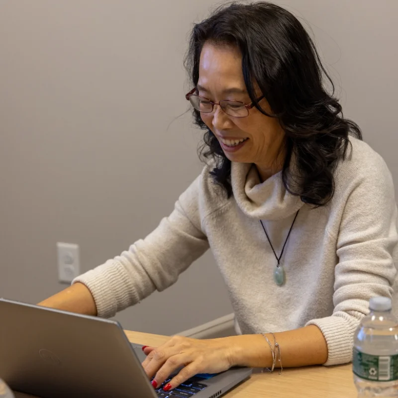 woman sitting at a table working on laptop