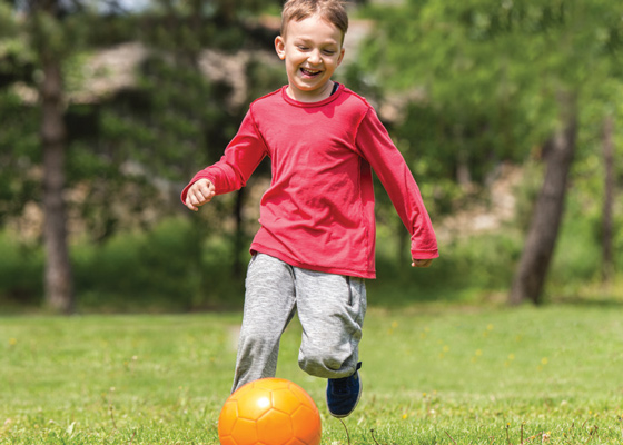 Little boy playing kickball